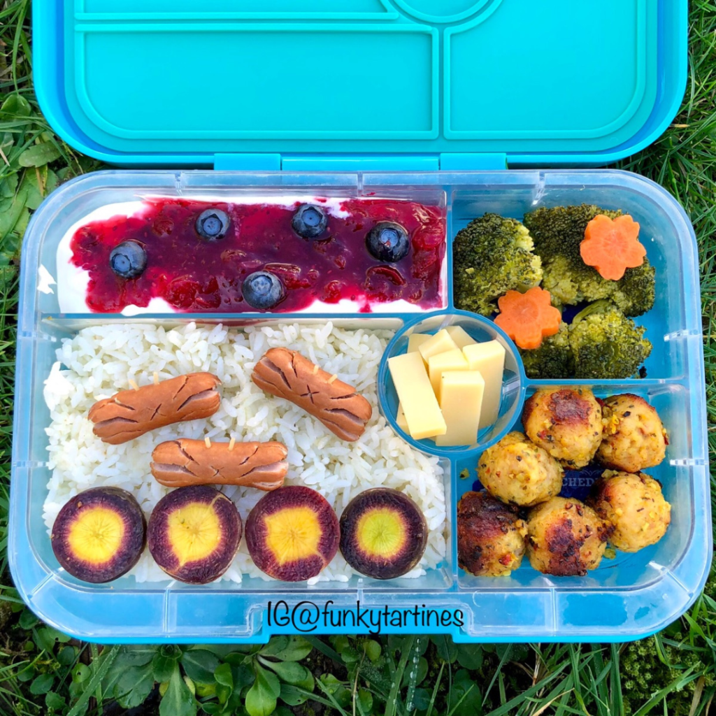 Teuko Lunchbox Community. lunchbox with many colors with white rice, green broccolis, yellow and violet carrots. Ruby red cranberry sauce.